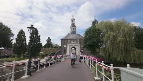 People-Riding-Bicycle-On-The-City-Gate-Zijlpoort-In-Leiden,-The-Netherlands