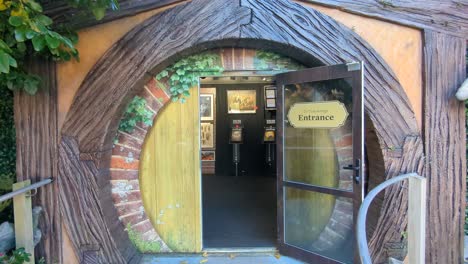 Walking-into-Hobbit-door-entrance-of-Weta-Cave-shop-and-museum-in-Wellington,-New-Zealand-Aotearoa