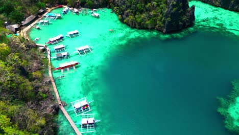 Ascenso-Aéreo-Del-Lago-Kayangan-Por-Encima-Del-Timelapse-De-Barcos-Turísticos-En-El-Mar-De-Coron