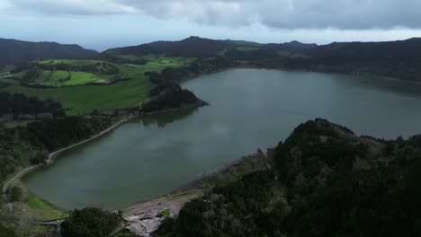 Luftdrohne-Zeigt-Die-Natürliche-Landschaft-Der-Blauen-Lagune-Auf-Den-Azoren-Bei-Tageslicht-Die-Skyline-Von-Portugal-über-Einer-Grünen,-Feuchten-Berglandschaft