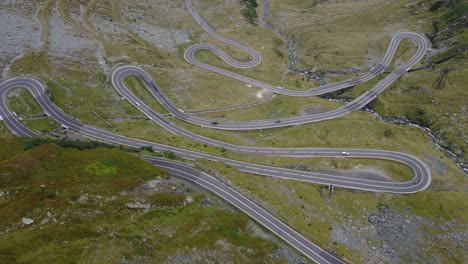 Vista-Aérea-De-La-Carretera-Transfagarasan-En-Los-Cárpatos-Rumanos-Con-Coches-Subiendo-La-Montaña