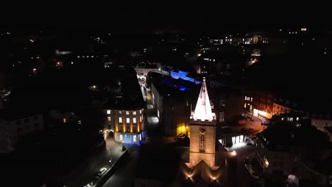 Imágenes-De-Drones-En-Aumento-En-La-Noche-De-La-Iglesia-Iluminada-De-La-Ciudad,-Los-Edificios-Del-Mercado-Y-La-Calle-Fountain-St-Peter-Port-Guernsey