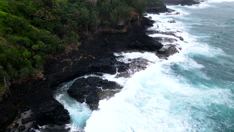 Aerial-Pan-of-Waves-Crashing-into-Rocks-of-Princeville,-HI