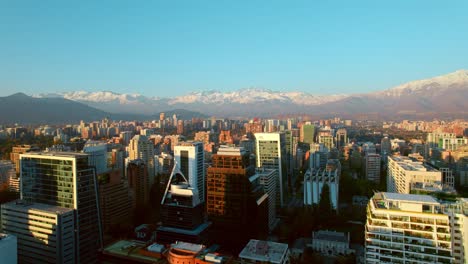 Aerial-establishing-shot-of-Scenic-Santiago-skyline-with-Snow-capped-Andes-mountains-in-Background,-Chile