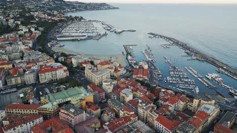 Aerial-view-of-Sanremo-Italy-coastal-town-with-old-port-yacht-moored-at-bay-drone-footage