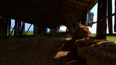 View-Inside-Old-Dilapidated-Barn-With-Hay-Bales-On-Sunny-Day