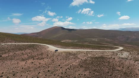 Aerial-orbiting-shot-of-a-car-parked-up-off-the-road-in-the-Andean-Mountains