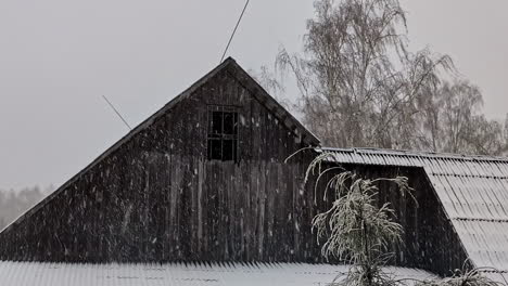 Filmische-Aufnahme-Des-Dachbodens-Eines-Verlassenen-Landhauses-Inmitten-Eines-Schneebedeckten-Waldes-Während-Eines-Wintersturms