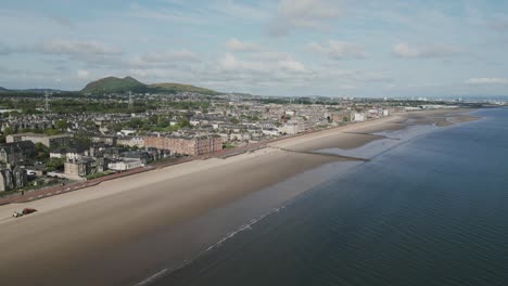 Seaside-town-in-Edinburgh,-Scotland-with-empty-beach-and-promenade-at-low-tide