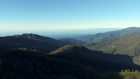 Aerial-view-Yungas-Forest,-lush-mountain-range-with-light-blue-sky-and-sunlight