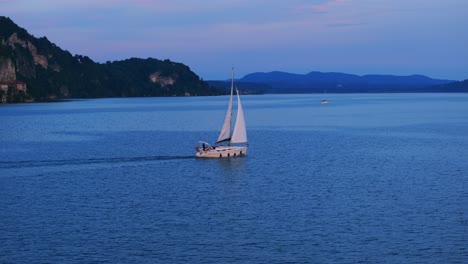 Velero-Navegando-Al-Atardecer-A-Través-Del-Increíble-Lago-Maggiore-En-Italia