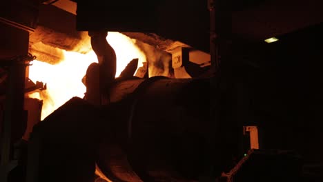 Intense-glow-of-molten-metal-in-a-dark-industrial-foundry,-highlighting-the-power-and-heat-of-metalworking