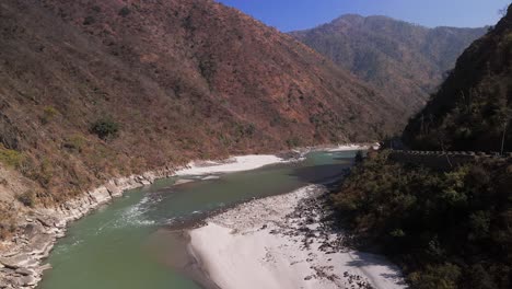 Malerische-Flusslandschaft:-Das-Bild-Zeigt-Einen-Ruhigen-Fluss,-Der-Sich-Unter-Einem-Klaren-Blauen-Himmel-Durch-üppig-Grüne-Berge-Schlängelt