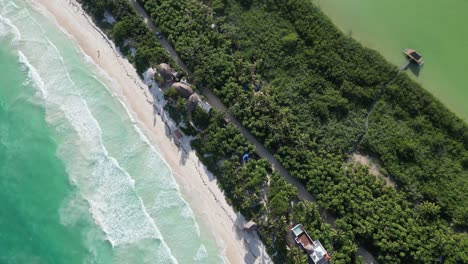 Aerial:-Narrow-strip-of-jungle,-beach-on-one-side,-lagoon-on-the-other