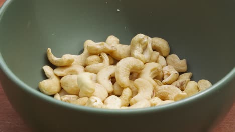 Cashew-Nuts-Falling-into-Green-Bowl-in-Slow-Motion