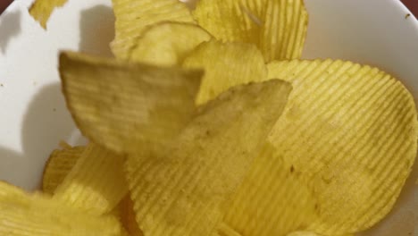 Above-View-of-Potato-Chips-Crisps-Tumbling-into-White-Bowl-in-Ultra-Slow-Motion---4K-Food-Clip