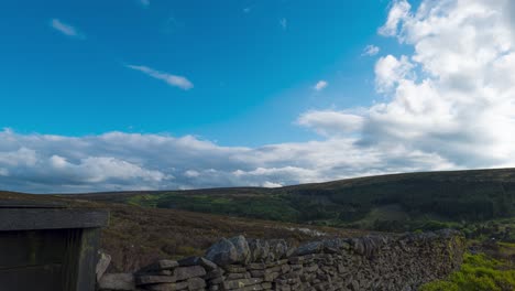 Timelapse-shot-of-white-cloud-movement-over-a-closed-mine-entrance-in-Goyt-Valley,-Buxton,-UK-during-evening-time