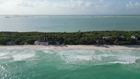 Aerial-dolly-shot-along-narrow-strip-of-beach,-jungle-at-Boca-Paila-MX