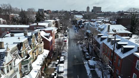 Aerial-lateral-shot-of-snowy-winter-town-in-USA-with-snow-covered-roofs-at-sunny-day