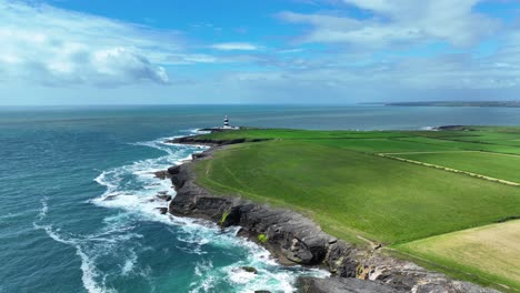 Ireland-Epic-locations-drone-flying-over-the-sea-along-the-Hook-Coastline-to-Hook-Lighthouse-in-Wexford-on-A-bright-summer-morning