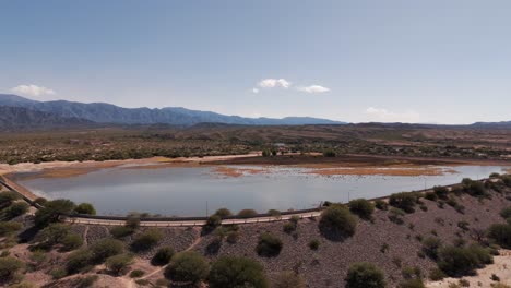 Drone-advancing-over-a-beautiful-dam-in-the-Cafayate-region,-Salta,-Argentina