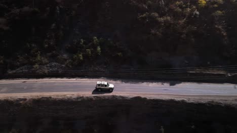 Un-Coche-Blanco-Conduciendo-Por-El-Pintoresco-Paisaje-Montañoso:-Ríos-Tranquilos,-Picos-Majestuosos-Y-Soledad,-Un-Todoterreno-Blanco-Viajando