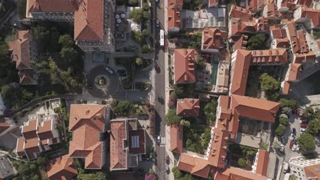 Filmische-Drohnenaufnahme-Von-Oben-Mit-Schloss-Am-Bus,-Der-Die-Straße-Hinunter-In-Die-Altstadt-Von-Dubrovnik-Fährt