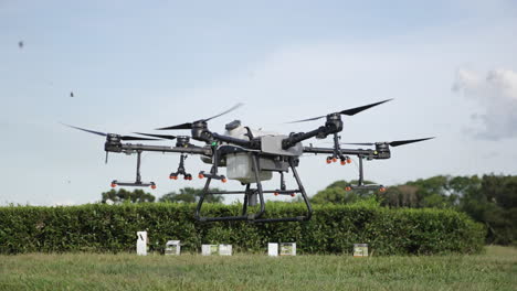 Drone-DJI-AGRAS-T30-starting-flight-in-the-nature-over-green-grass-and-bushes