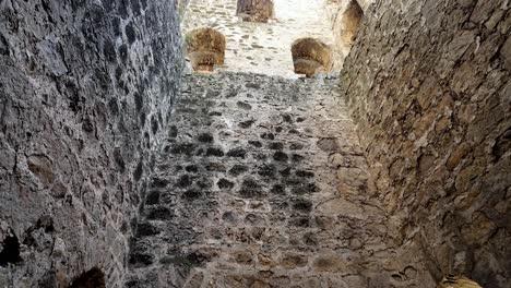 Una-Vista-Hacia-Arriba-Desde-El-Interior-De-La-Fortaleza-Genovesa-En-Feodosia,-Crimea,-Rusia,-Mostrando-Los-Muros-De-Piedra-Y-Las-Aberturas-Arqueadas.