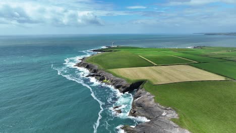 Ireland-Epic-locations-drone-flying-along-the-coast-to-Hook-Head-Lighthouse-with-rough-seas-on-a-beautiful-summer-morning-in-Wexford