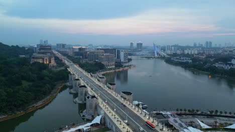 Luftaufnahme-Der-Malerischen-Putra-Brücke-In-Malaysia-Am-Abend,-Die-Den-Ruhigen-Fluss-Und-Die-Stadtlandschaft-Einfängt