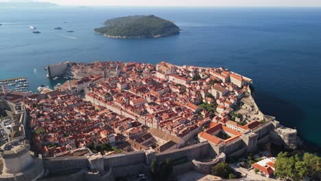 Sonnenaufgangsflug-über-Die-Altstadt-Von-Dubrovnik-Mit-Filmischer-Schwenkung-Und-Glasklarem-Wasser