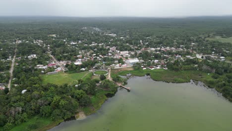 Aerial-rotates-over-small-pueblo-on-Noh-Bec-Lagoon-in-Mexican-jungle