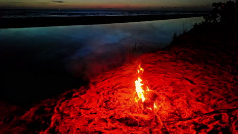 Campfire-on-a-beach-of-the-ocean-or-a-large-lake---tilt-up-reveal-the-twilight-sky