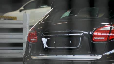 White-luxury-car-during-inspection-in-a-garage-with-tools-visible-in-the-background,-close-up