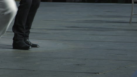 Closeup-of-dancers'-feet,-one-wearing-black,-one-in-white,-on-stage