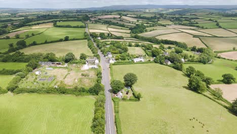 Silver-estate-car-driving-down-remote-road-in-Devon,-England