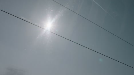 Sunlight-streaming-through-train-window,-brilliant-flare-and-reflections-on-a-clear-day