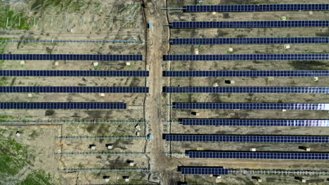 Solar-panel-park-under-construction,-top-down-aerial-view,-green-electricity-production