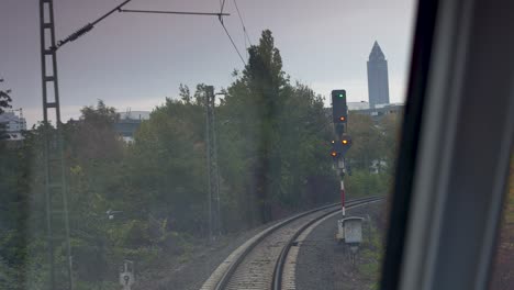 Vista-Del-Conductor-Desde-Un-Tren,-Capturando-Vías-Curvas-Y-Una-Luz-Verde-Más-Adelante-En-Un-Entorno-Urbano.