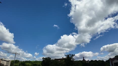 Nubes-Que-Se-Mueven-Rápidamente-Sobre-La-Ciudad,-Fondo-Azul.