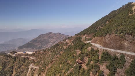 Hochgelegener-Steiler-Gebirgspass-Im-Himalaya,-Kurvenreiche-Straße-Schlängelt-Sich-Durch-Bergige-Landschaft,-Umgeben-Von-üppigen-Grünen-Bäumen