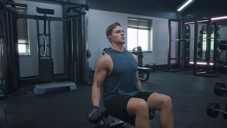 Hombre-Caucásico-Haciendo-Flexiones-De-Bíceps-Con-Pesas-Pesadas-En-El-Gimnasio-Oscuro