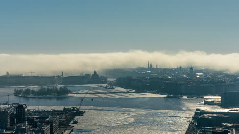 Time-lapse-of-smoke-fog-swallowing-the-Helsinki-skyline,-spring-day-in-Finland