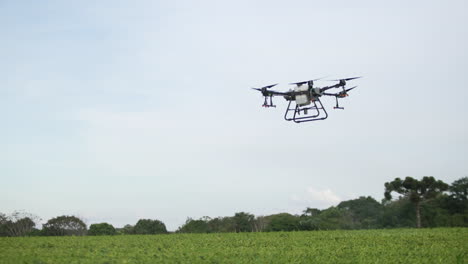 Drone-Dji-Agras-T30-Moviéndose-En-El-Aire-Sobre-Un-Campo-Verde-En-Cámara-Lenta