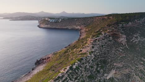 Flying-above-rugged-coastal-limestone-ridge,-bright-sunlight-in-Mallorca