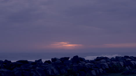 Bewölkter-Sonnenuntergang-An-Einem-Regnerischen-Tag-Mit-Blick-Vom-Strand-Und-Den-Felsen