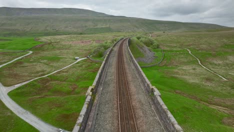 Curved-railway-tracks-crossing-viaduct-railway-bridge-over-English-moorland