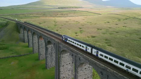 Personenzug-überquert-Eisenbahnbrücke-über-Nordenglische-Moorlandschaft-Zur-Goldenen-Stunde