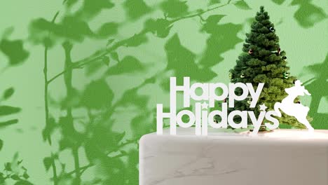 Small-Christmas-tree-with-"Happy-Holidays"-sign-on-marble-platform-with-green-floral-shadow-background